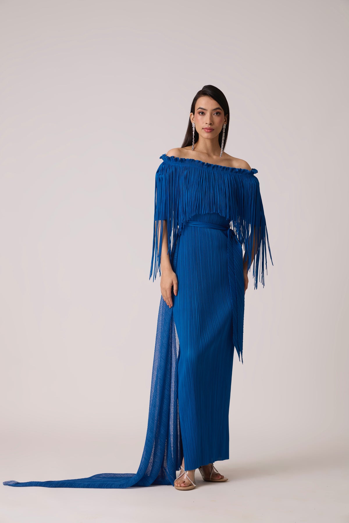 Model wearing a pleated royal blue dress with a fringe bodice.